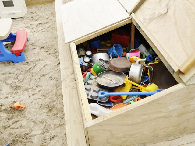 Storage of sand pit toys in wooden storage box